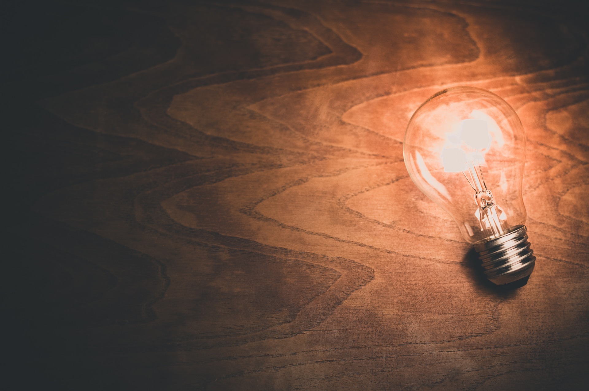 a photo of a light bulb shining amid darkness